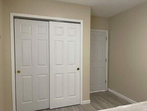Simple, unadorned hallway with sliding door and two classic doors.