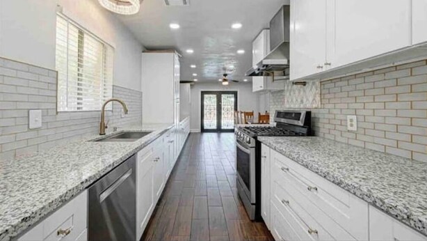 A modern kitchen with white cabinets, granite countertops, and a central island. - Blue Lagoon Spanish Retreat 5BRs and Pool Airport (Houston)