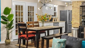 Una cocina moderna con comedor, que incluye una mesa de madera, sillas y un florero con flores.