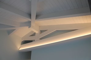 A modern architectural ceiling with white beams and recessed lighting. - Tenuta Bellelli (Castellabate)
