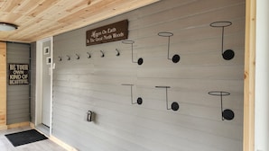 A wall with a sign that reads "Heaven On Earth In The Great North Woods" and a series of hooks with circular ends. - Cozy getaway mins from Michigan Tech, Ski & Snowmobile trails & Lake Superior (Hancock)