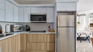 Une cuisine moderne avec des meubles en bois, un réfrigérateur en acier inoxydable, un four à micro-ondes et un grille-pain.