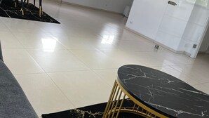 A spacious room with a dining area, a black marble table, and a modern design.