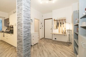 Eine moderne Küche mit einer zentralen Kochinsel, einem Einbauofen und einem weißen Schrank.
