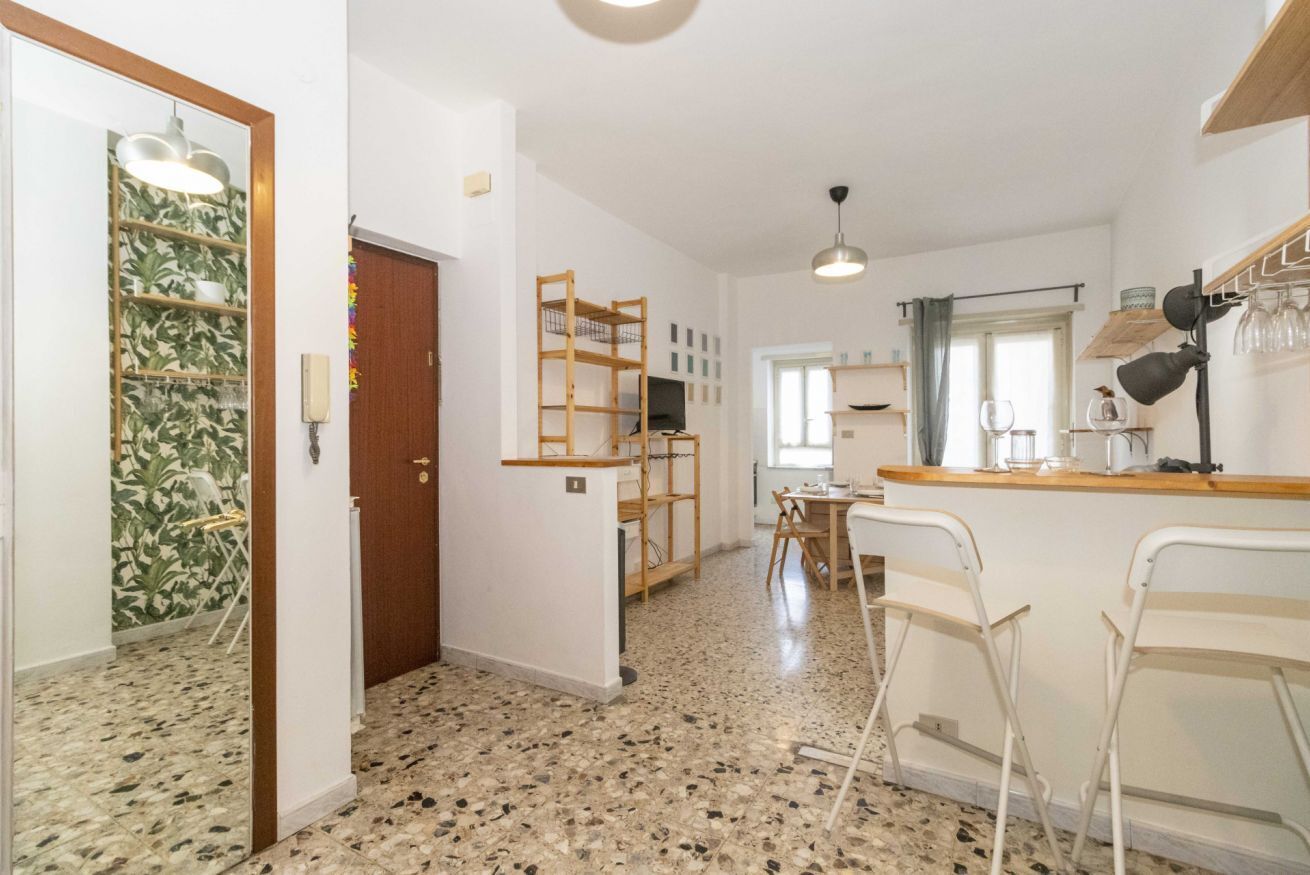 A kitchen with a wooden counter, a dining table, and chairs.