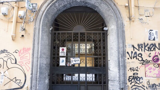 An arched entrance with a metal gate, graffiti on the walls, and a sign indicating a no parking zone. - GuestHost - Veiled Christ Bilo Apartment (Napoli)