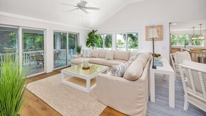 Amplia sala de estar con un sofá grande, una mesa de centro y un comedor con una silla y una mesa.
