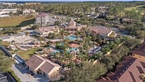 Ein Resort mit mehreren Gebäuden, einem zentralen Poolbereich und umgebender Bepflanzung.