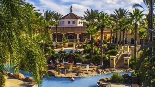 Ein Resort mit Pool, Palmen und einem Gebäude mit Kuppeldach.