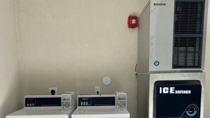 Two front-loading washing machines and an ice dispenser unit. - Bluestar Inn (Houston)