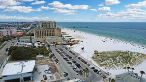 A beachfront hotel with a parking lot, beach access, and ocean view.