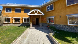 Un edificio di legno a due piani con un vialetto in pietra che conduce all'ingresso.