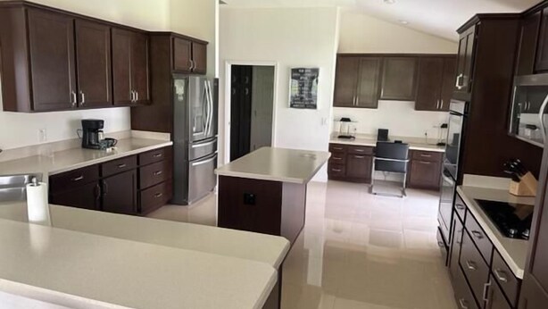 Una cocina moderna con armarios de madera oscura, electrodomésticos de acero inoxidable y una isla central.
