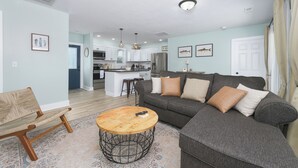 A modern living room with a grey sofa, a wooden coffee table, and a patterned rug. - Channel Charmer - Prime Gun Lake Waterfront Stay (Shelbyville)