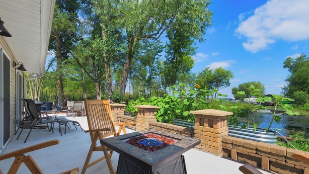 An outdoor patio with a fire pit, wooden chairs, and a view of a lake. - Channel Charmer - Prime Gun Lake Waterfront Stay (Shelbyville)
