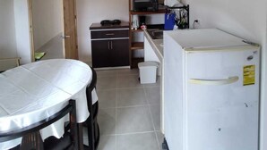 A compact kitchen with a refrigerator, microwave, and small sink.