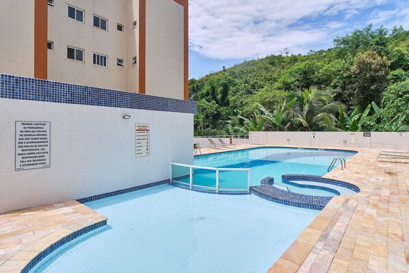 Una piscina con escalones de azulejos y un cartel que indica que no se permite el acceso a niños menores de 12 años.
