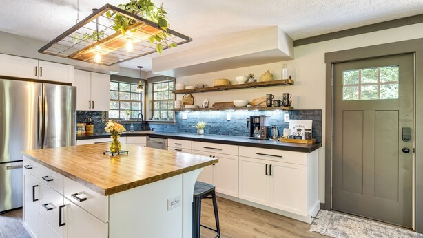 A modern kitchen with white cabinets, a wooden island, stainless steel appliances, and a farmhouse-style door. - Secluded Mountain Retreat: 30 Mi to Asheville! (Old Fort)