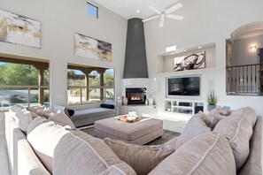 A modern living room with a fireplace, large TV, and comfortable seating. - Hot Property/Family Friendly/Pool&Spa/Sleeps 14 (Tucson)