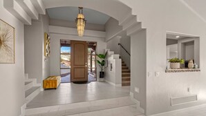 A spacious hallway with a wooden door, a staircase, and a chandelier. - Hot Property/Family Friendly/Pool&Spa/Sleeps 14 (Tucson)