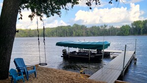 Une jetée au bord du lac, dotée d’un espace de repos abrité, d’une chaise suspendue et d’une plage de sable.