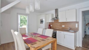 A modern kitchen with white cabinets, a wooden countertop, and a built-in oven. - Traum-ferienwohnung Alpenblick, 75 qm, Balkon und Bergblick (Bad Aibling)