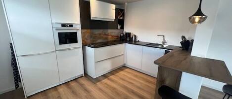 Een koelkast, een oven, een kookplaat, een vaatwasser