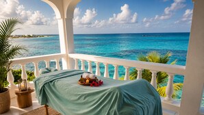 Een balkon met een bed, een bloempot, een kaars en een dienblad met toiletartikelen.