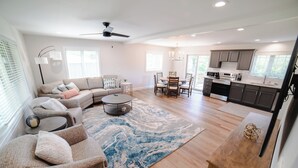 A spacious living room with a sofa, coffee table, and dining area.