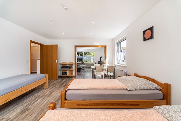 Una habitación moderna con dos camas de madera, un escritorio y una silla.