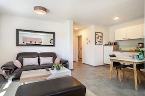 Un salon moderne comprenant un canapé, une table basse et un coin repas avec une table et des chaises.