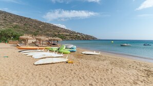 A beach with boats, a bench, and a thatched-roof structure. - Holiday Home '1b Kypri Seaview Perasma Studio' with Sea View, Wi-Fi and Air Conditioning (Kypri)