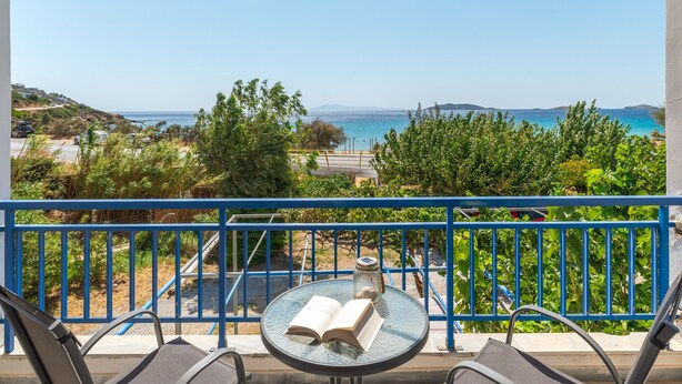 A balcony with a view of the sea, a table with an open book, and a decorative vase. - Holiday Home '1b Kypri Seaview Perasma Studio' with Sea View, Wi-Fi and Air Conditioning (Kypri)