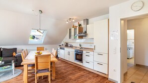 Una cucina moderna con mobili bianchi, un tavolo da pranzo in legno e un forno integrato.