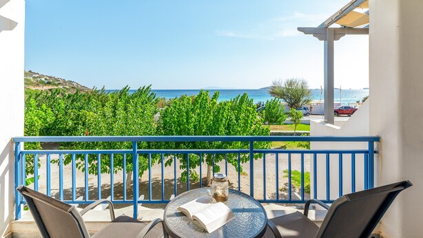 A balcony with a view of the sea, a table with a book and a glass jar, and a blue railing. - Holiday Home '3 Kypri Seaview Perasma Studio' with Sea View, Wi-Fi and Air Conditioning (Kypri)