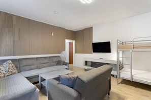 A modern living room with a sofa, coffee table, and a bunk bed.