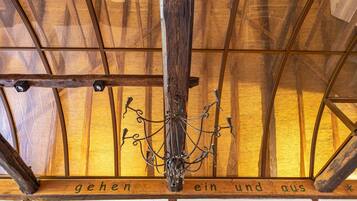 A wooden ceiling with a chandelier and a sign with text.