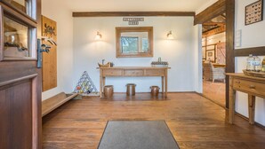 Un intérieur en bois avec une enseigne indiquant « JUTTASOF 1994 », un banc en bois orné de trois pots et un petit sapin de Noël.