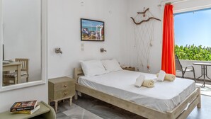 A bedroom with a bed, bedside tables, a desk, a chair, a window with a view, and a wall-mounted picture. - Holiday Home '6 Kypri Seaview Perasma Studio' with Sea View, Wi-Fi and Air Conditioning (Kypri)
