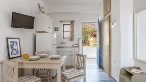 A compact kitchen with a dining area, a television, and a view of the outdoors. - Holiday Home '6 Kypri Seaview Perasma Studio' with Sea View, Wi-Fi and Air Conditioning (Kypri)