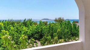 A balcony with a view of the sea and a distant island.