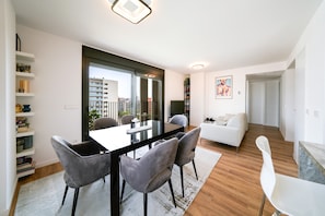Una sala moderna con comedor, un sofá y un televisor.