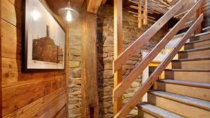 A wooden staircase with a stone wall and a framed picture on the wall. - Chalet "1175" – Perfect for Groups of 6 to 9 Guests (Arvier AO)
