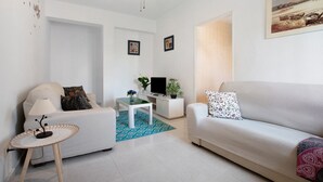 A living room with a sofa, a coffee table, a TV stand, and a ceiling fan. - Apartment 'Prealsa Benalmádena' with Sea View, Shared Pool and Private Terrace (Benalmádena)