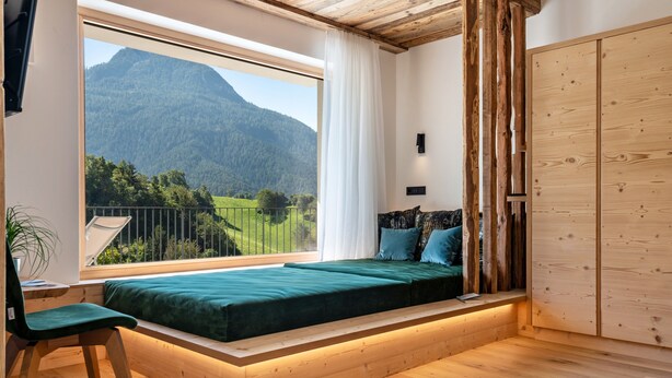 A bedroom with a built-in window seat, a bed, a desk, and a wardrobe. - Holiday Apartment "Chalet Kasch Glück" with Mountain View, Private Terrace & Wi-Fi (Fiè allo Sciliar)
