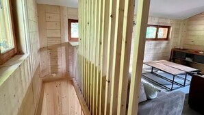 Un intérieur en bois comprenant un escalier, un coin repas et un canapé.