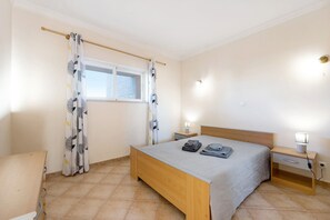 Une chambre à coucher avec un lit, des rideaux, des lampes de chevet et une table de chevet.