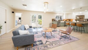 A spacious living room with a gray sofa, a coffee table, and a patterned rug. - 4,500 sq-ft retreat with a pool and hot tub in the middle of wine country!  (Templeton)