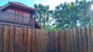 Una valla de madera con una casa al fondo.