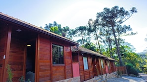 Una hilera de cabañas de madera con zócalos de piedra, amplias ventanas y un camino de piedra que conduce a la entrada.